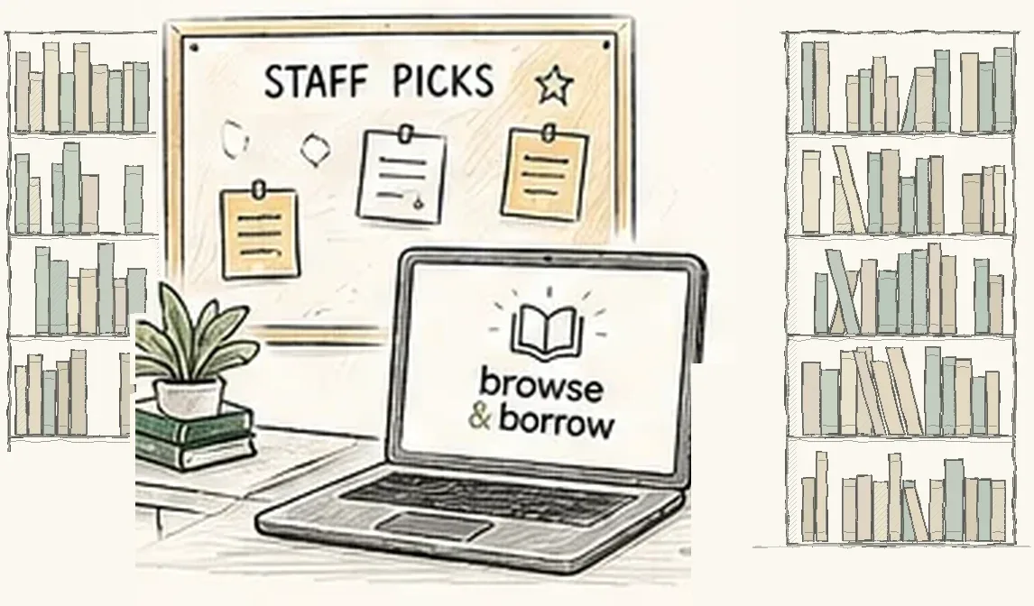 A librarian’s desk with a staff picks board and a laptop, with tall bookshelves on either side